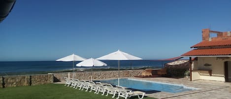 Una piscina al aire libre, cabañas de piscina gratuitas, sombrillas