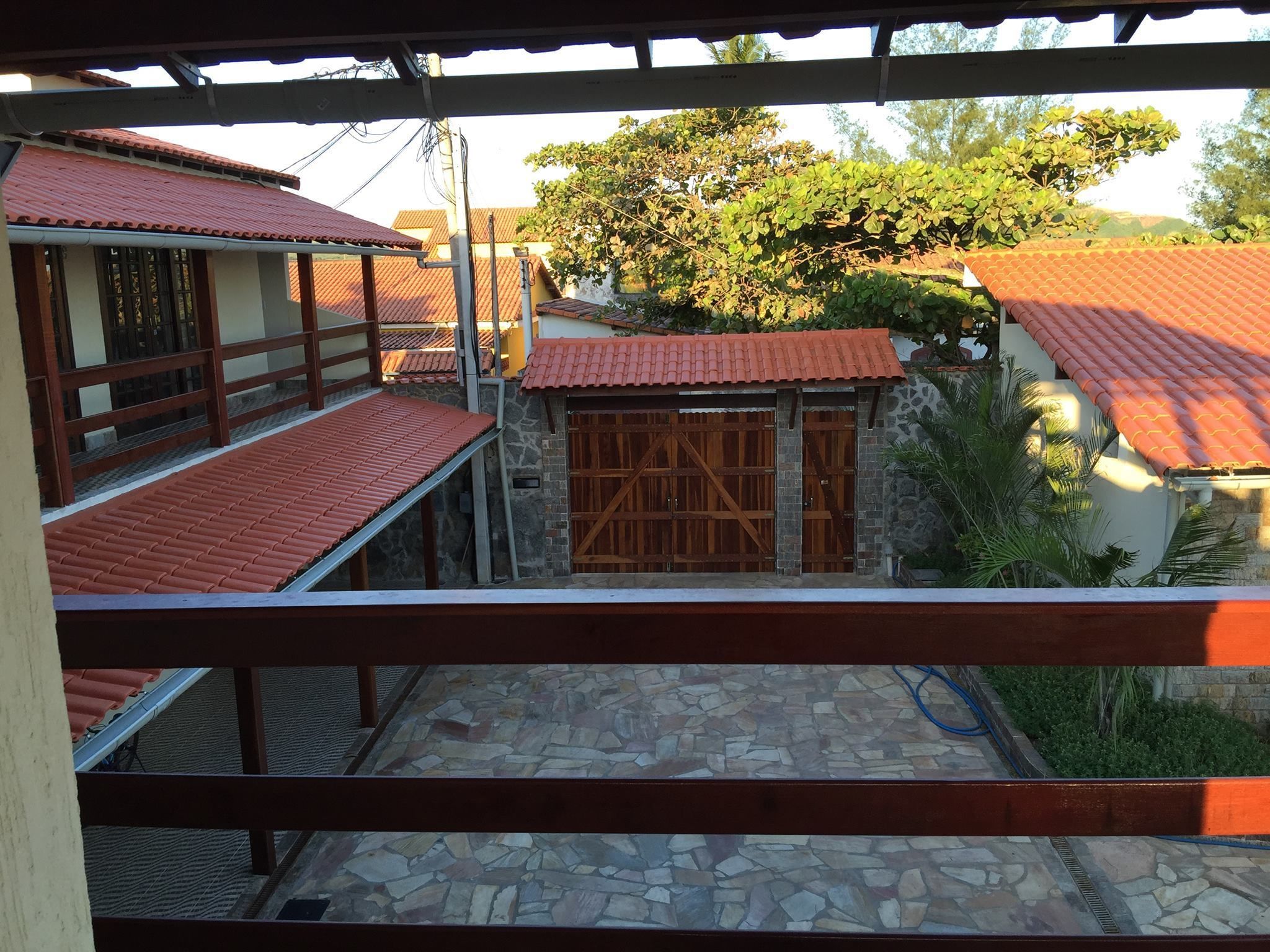 Un patio con suelo de piedra, un portón de madera y edificios con tejados de tejas rojas.