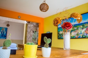 A room with a wooden table, various potted cacti, a laptop, and a painting on the wall. - Pousada Costa Dourada (Ipojuca)