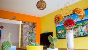 A room with a cactus collection, a painting, and a laptop on a table. - Pousada Costa Dourada (Ipojuca)