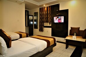 A hotel room with two beds, a TV, a coffee maker, and a small table. - Hotel Suzi International (New Delhi)