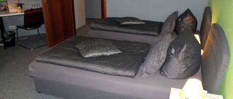 Une chambre avec deux lits, un bureau et une chaise.