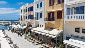 A coastal hotel with multiple balconies, outdoor seating, and a view of the marina. - Casa Ithomi (Chania)