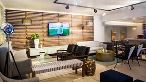 A modern living room with a TV, sofa, chairs, and a dining area. - San Lameer Villa Rentals Two Bedroom Standard 1928 (Southbroom)