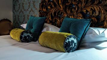 A bed with decorative pillows and a headboard with intricate carvings.