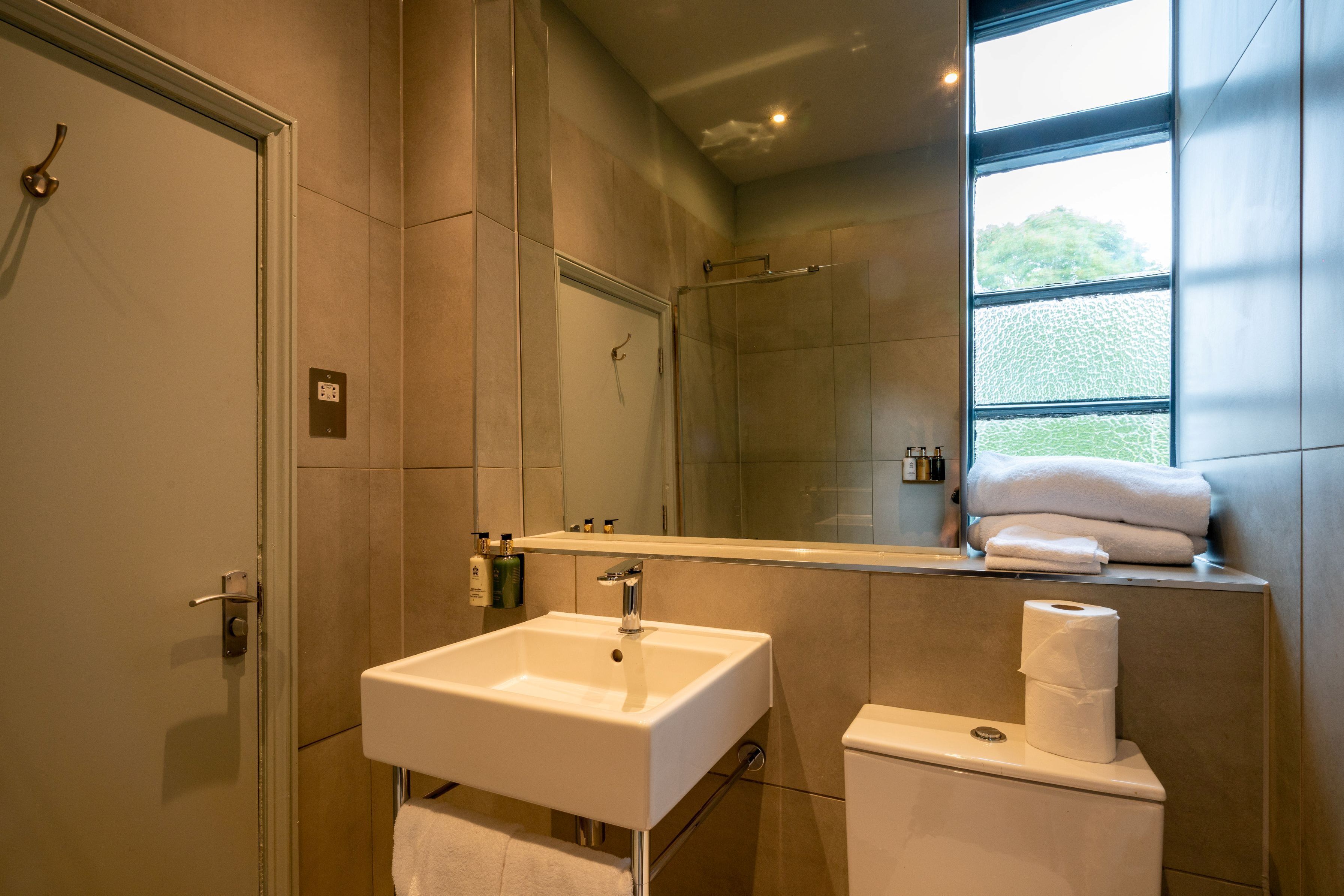 A modern bathroom with a sink, toilet, and shower.