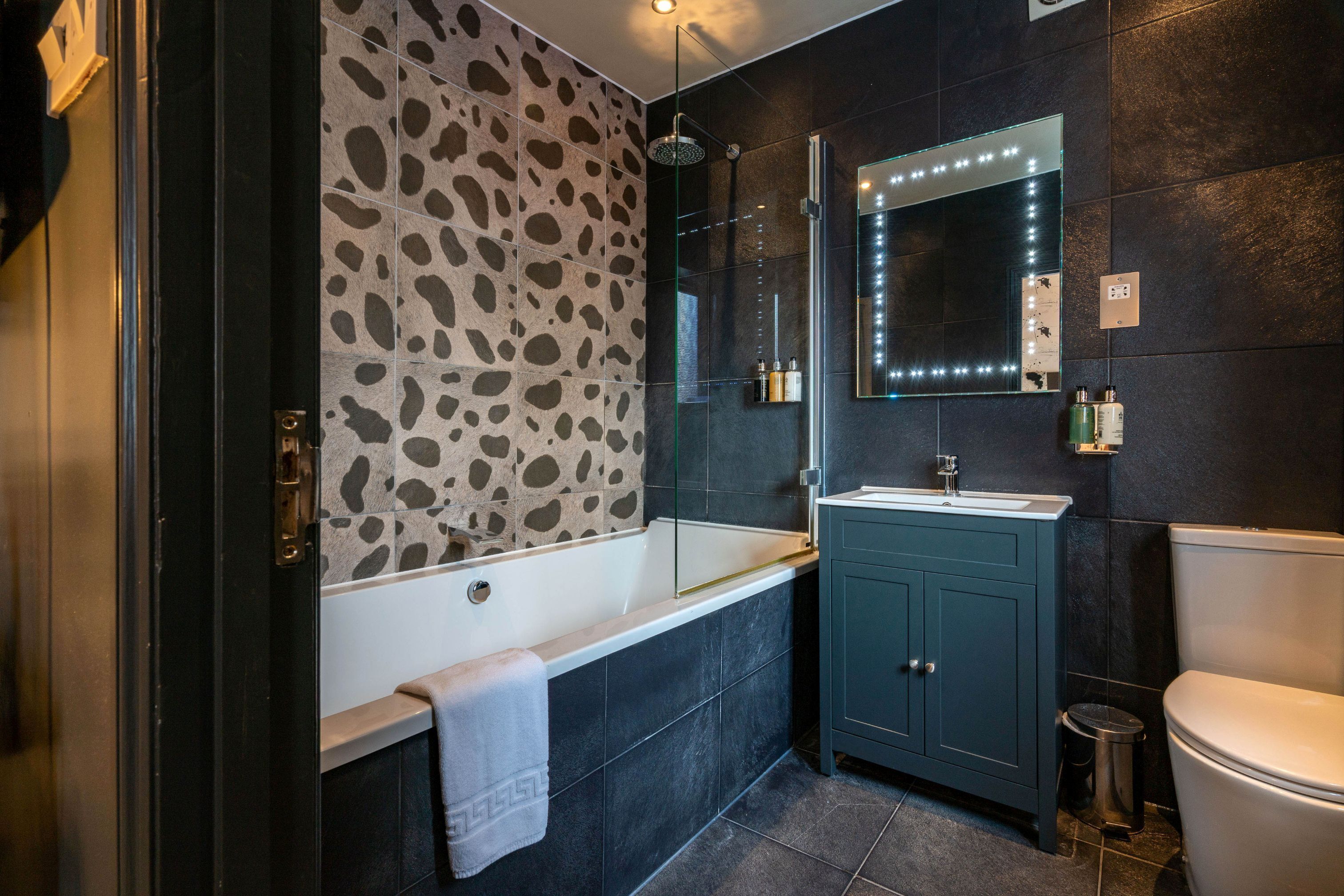 A modern bathroom with a freestanding bathtub, a vanity with a mirror, and a toilet.
