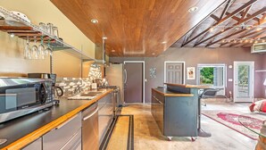 A modern kitchen with stainless steel appliances, a wooden ceiling, and a built-in bar area. - Brinnon Gardens (Brinnon)