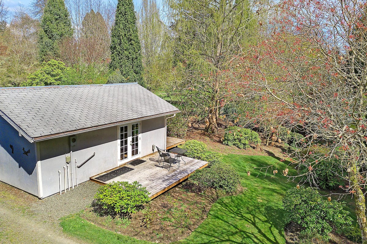 A modern house with a sloped roof, a covered porch, and a well-maintained garden.