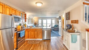 A modern kitchen with wooden cabinets, stainless steel appliances, and a central island. - Sweet Caroline Inn (Ocean Shores)