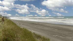 A beach with a grassy foreground and a view of the ocean. - Sweet Caroline Inn (Ocean Shores)