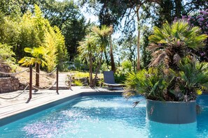 Una piscina al aire libre, sillones reclinables de piscina