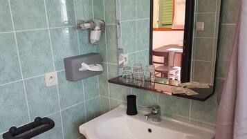 A bathroom with a white sink, a mirror, and a towel rack.