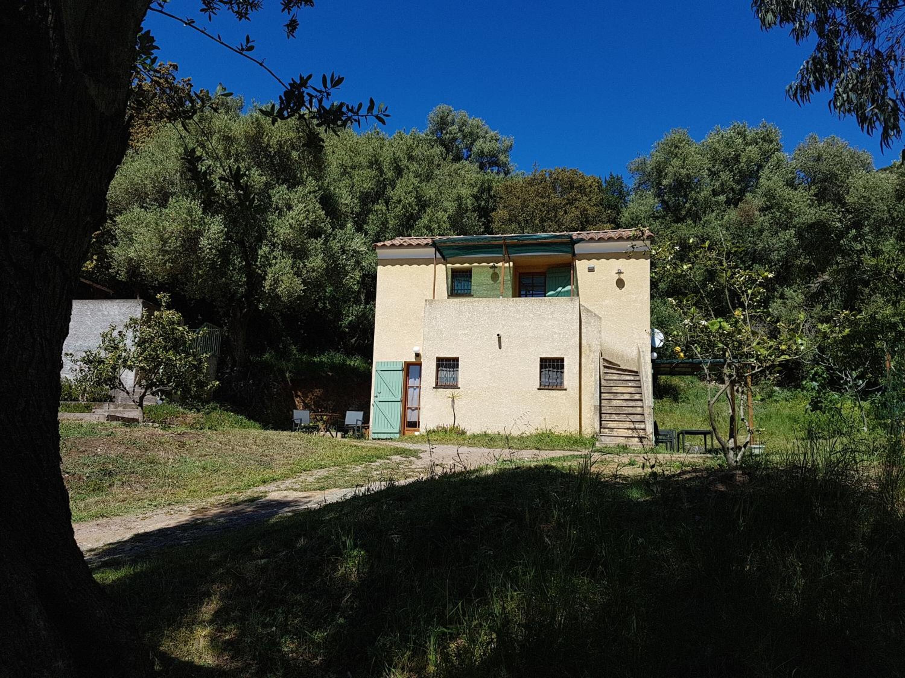A small, single-story house with a flat roof, a front door, and a small porch.