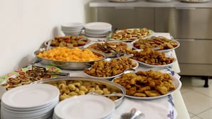 A buffet table with various dishes and plates. - Hotel Zamagna (Cesenatico)