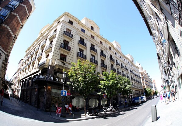 A multi-story building with a classic architectural style, featuring balconies and a ground-level entrance. - Hostal Sol Square Madrid (Madrid)