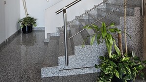 A modern staircase with metal railings, granite steps, and potted plants.