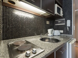 A kitchen with black and white tiled backsplash, stainless steel appliances, a sink, and a microwave. - Dto Libertad 1 by For Rent Argentina (Buenos Aires)