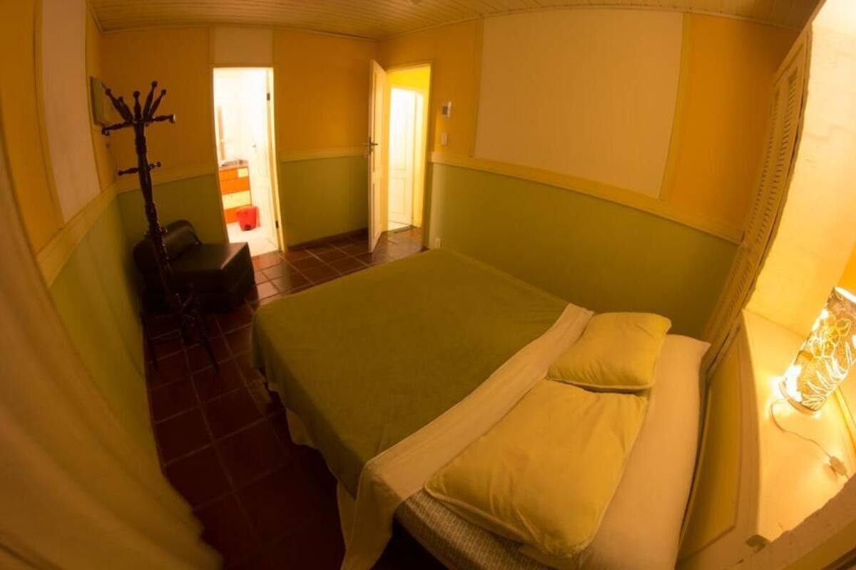 Une chambre d’hôtel avec un lit, une chaise et un porte-manteau.