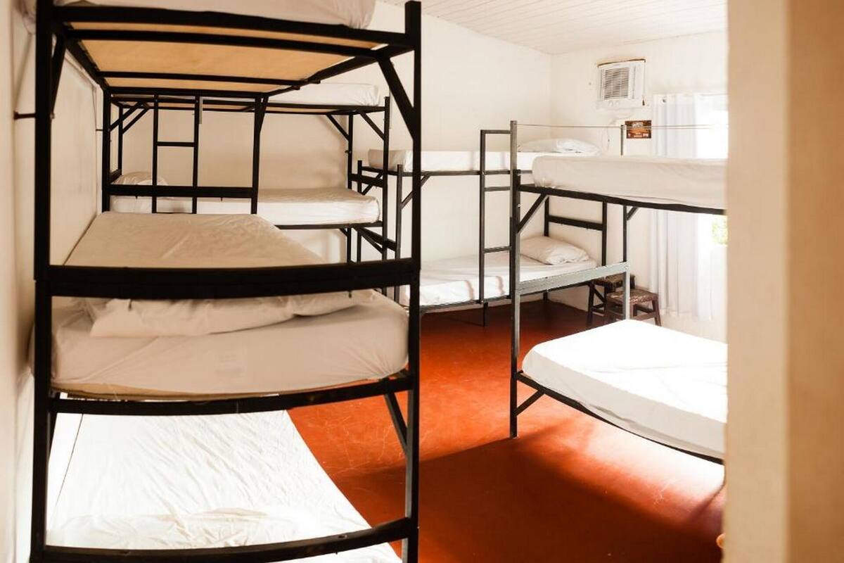Une chambre de dortoir avec des lits superposés, une fenêtre et un radiateur.