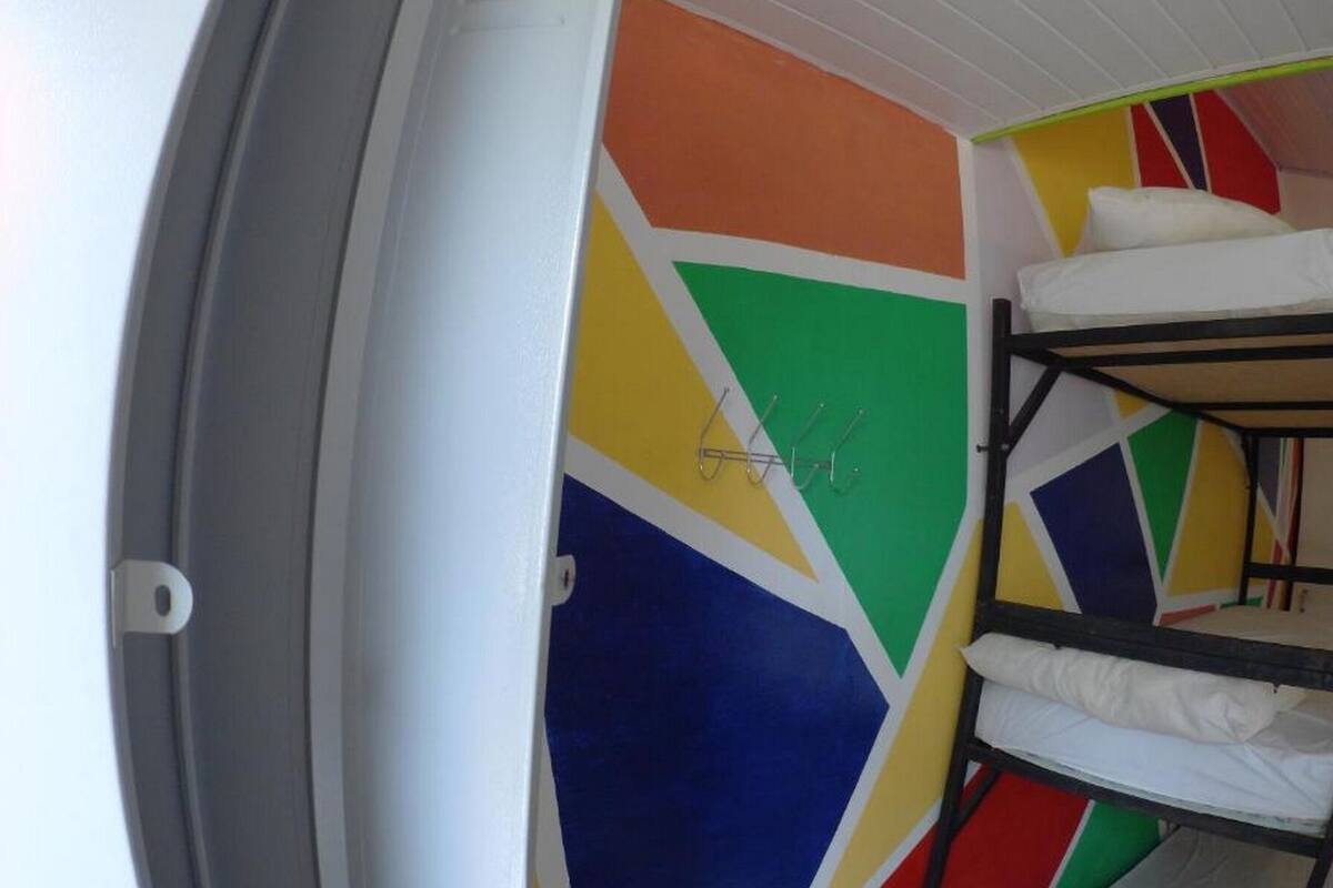 Un lit superposé avec un motif géométrique coloré sur le mur.