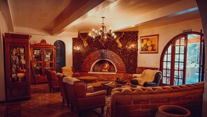 A cozy living room with a fireplace, leather sofas, and a chandelier.