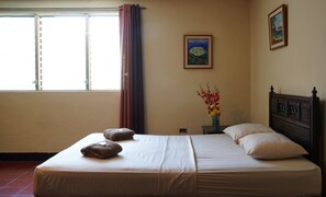 A hotel room with a bed, pillows, a vase with flowers, and a painting on the wall. - El Arca de Noé Lodging (Granada)