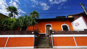 A building with a staircase leading to a door, surrounded by palm trees and a clear blue sky. - El Arca de Noé Lodging (Granada)
