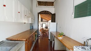 A narrow kitchen with wooden countertops, a sink, and a stove. - El Arca de Noé Lodging (Granada)