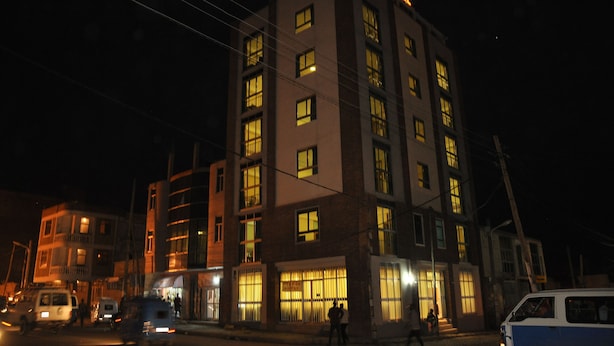 Un hotel de varios pisos con ventanas iluminadas y un letrero en la parte superior.