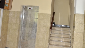 Una escalera con barandilla metálica que lleva a un rellano en el segundo piso.