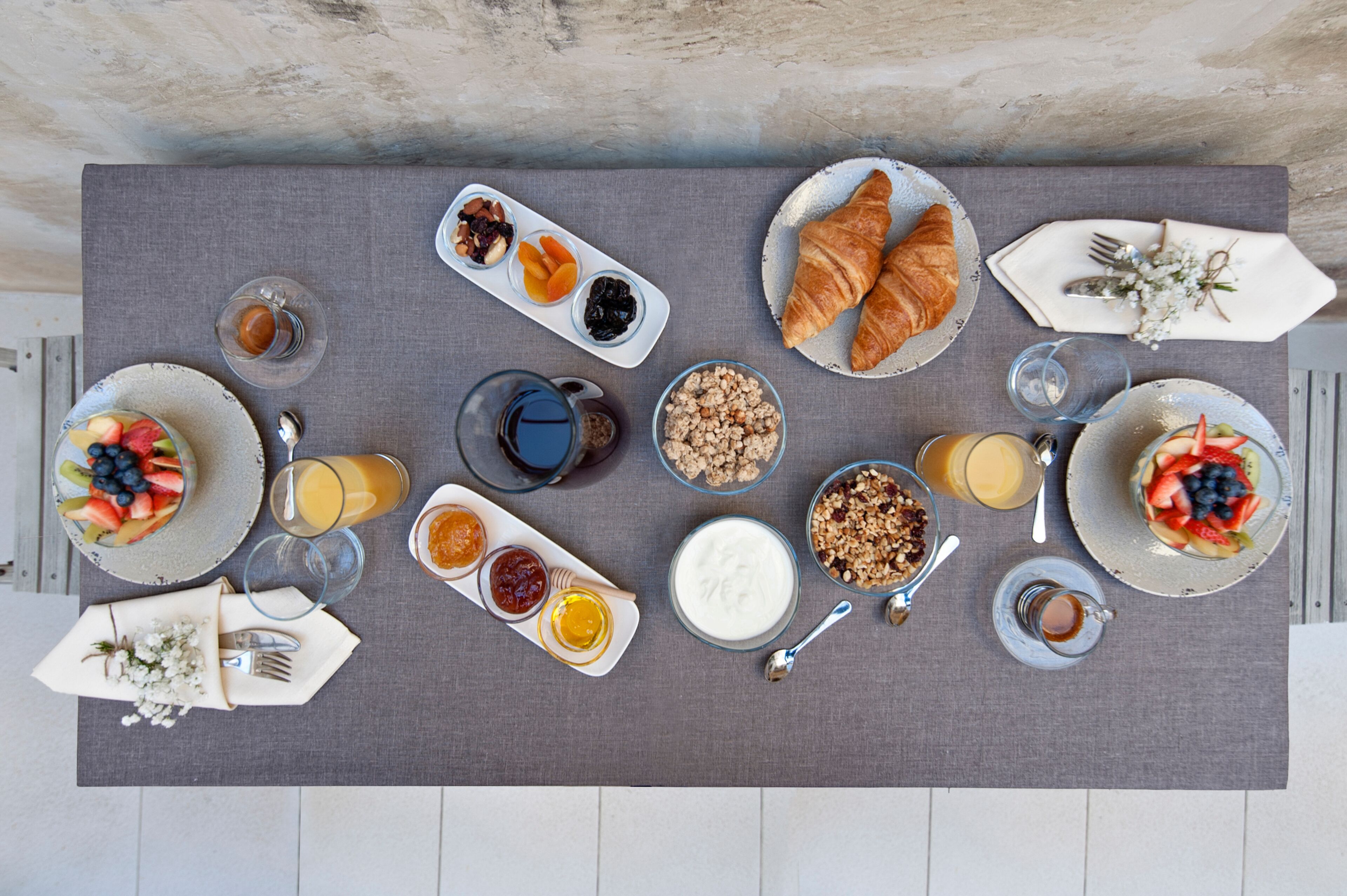 A breakfast table with various food items and drinks.