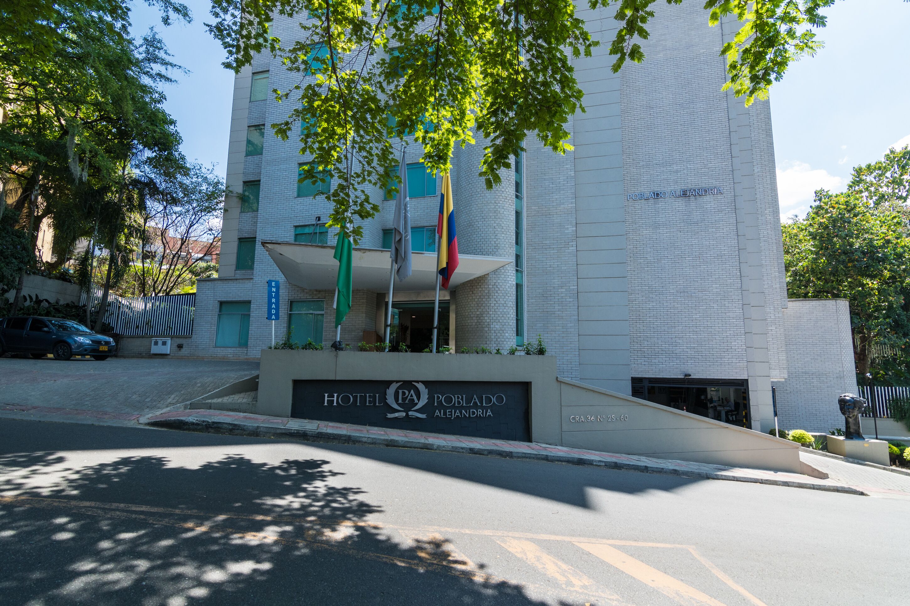 A modern building with a sign for Hotel Poblado Alejandro.