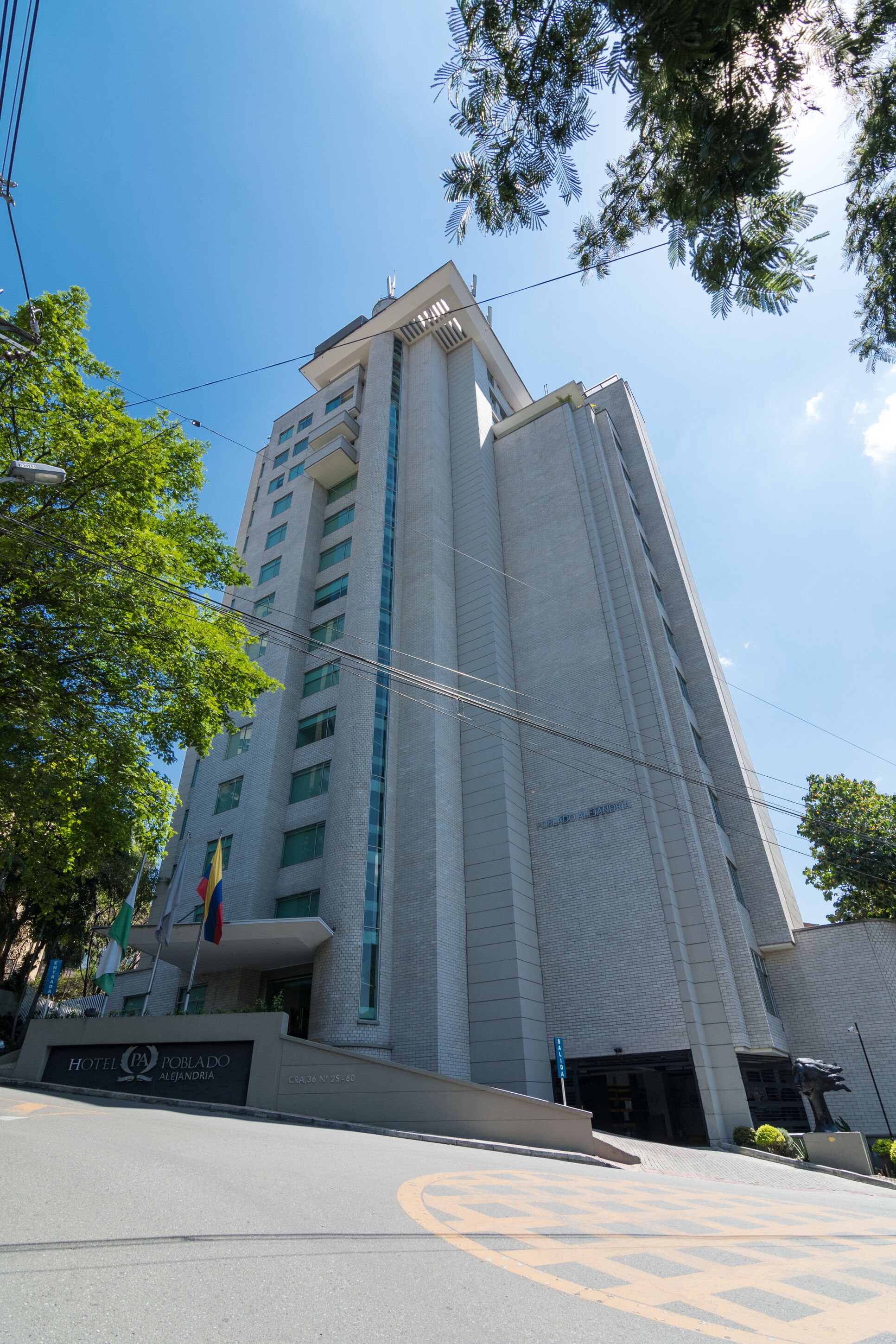 A tall, modern building with a prominent entrance and a sign indicating it is a hotel.