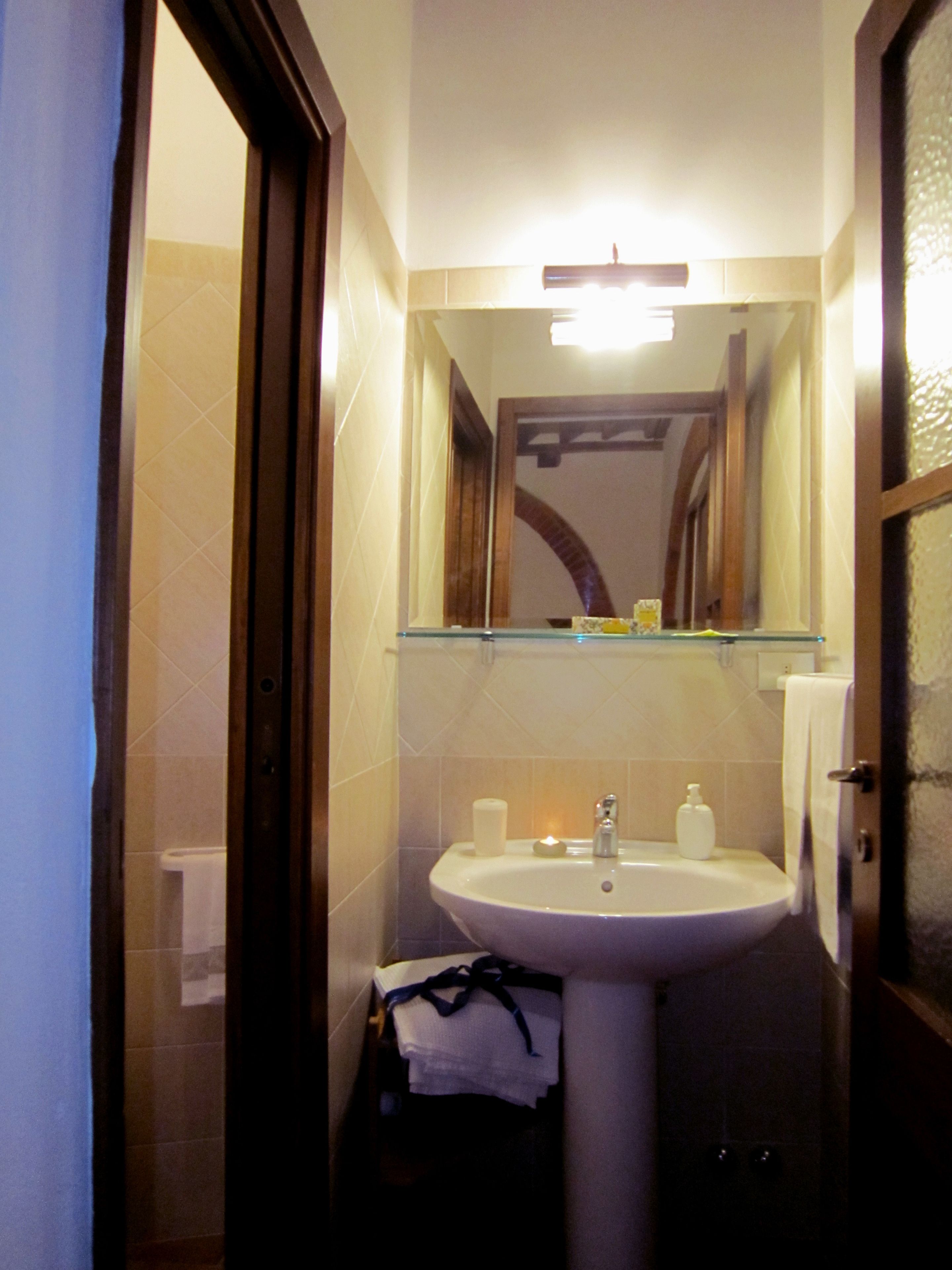 Un baño con lavabo, espejo y toallero.
