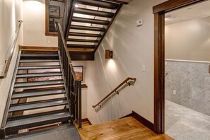 Un escalier avec des rampes en métal, des marches en bois et un cadre photo accroché au mur.