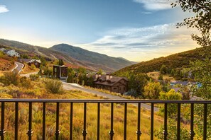En vacker utsikt över en bergsby med hus, en slingrande väg och en klar himmel.