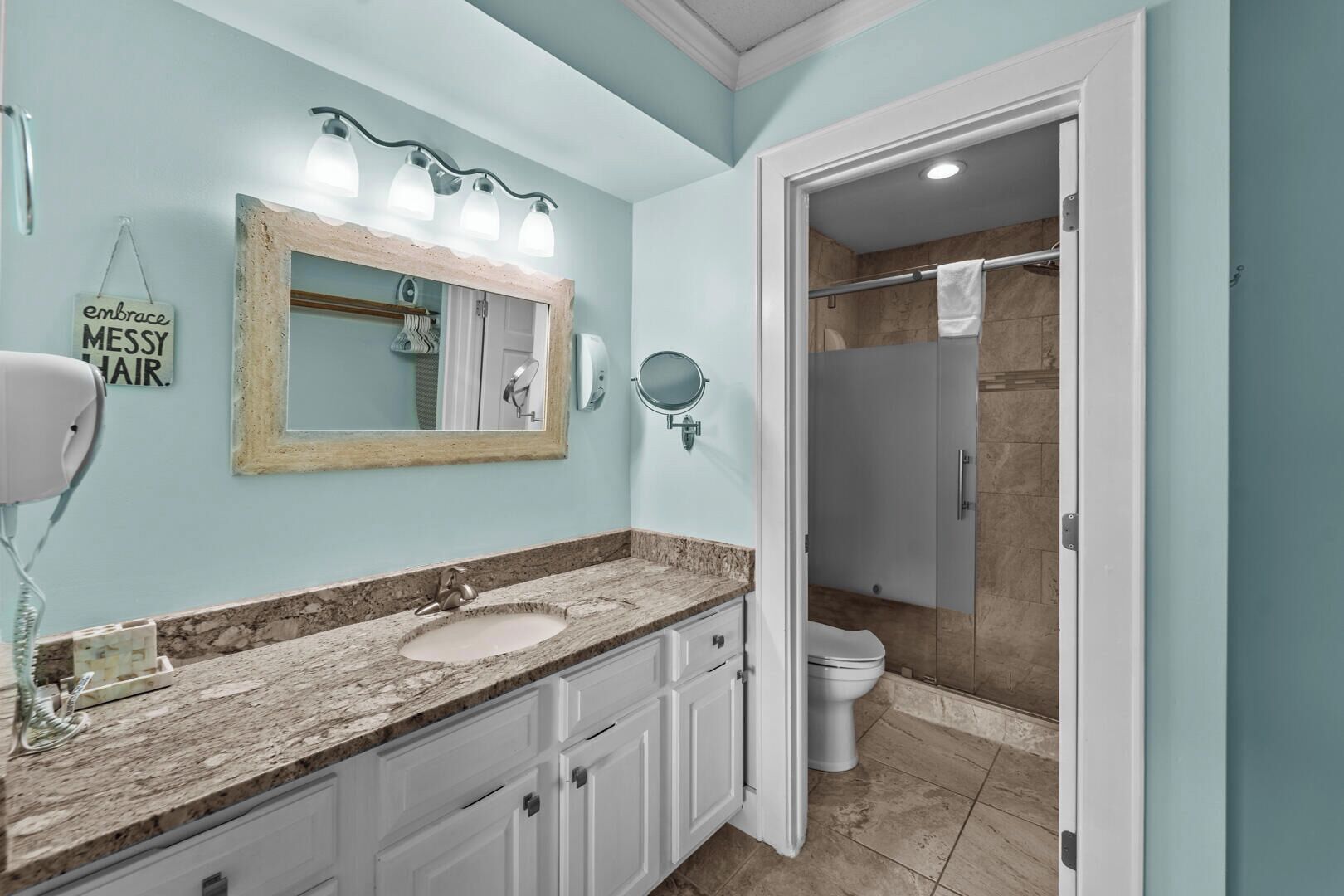 A bathroom with two sinks, a large mirror, and a shower area.