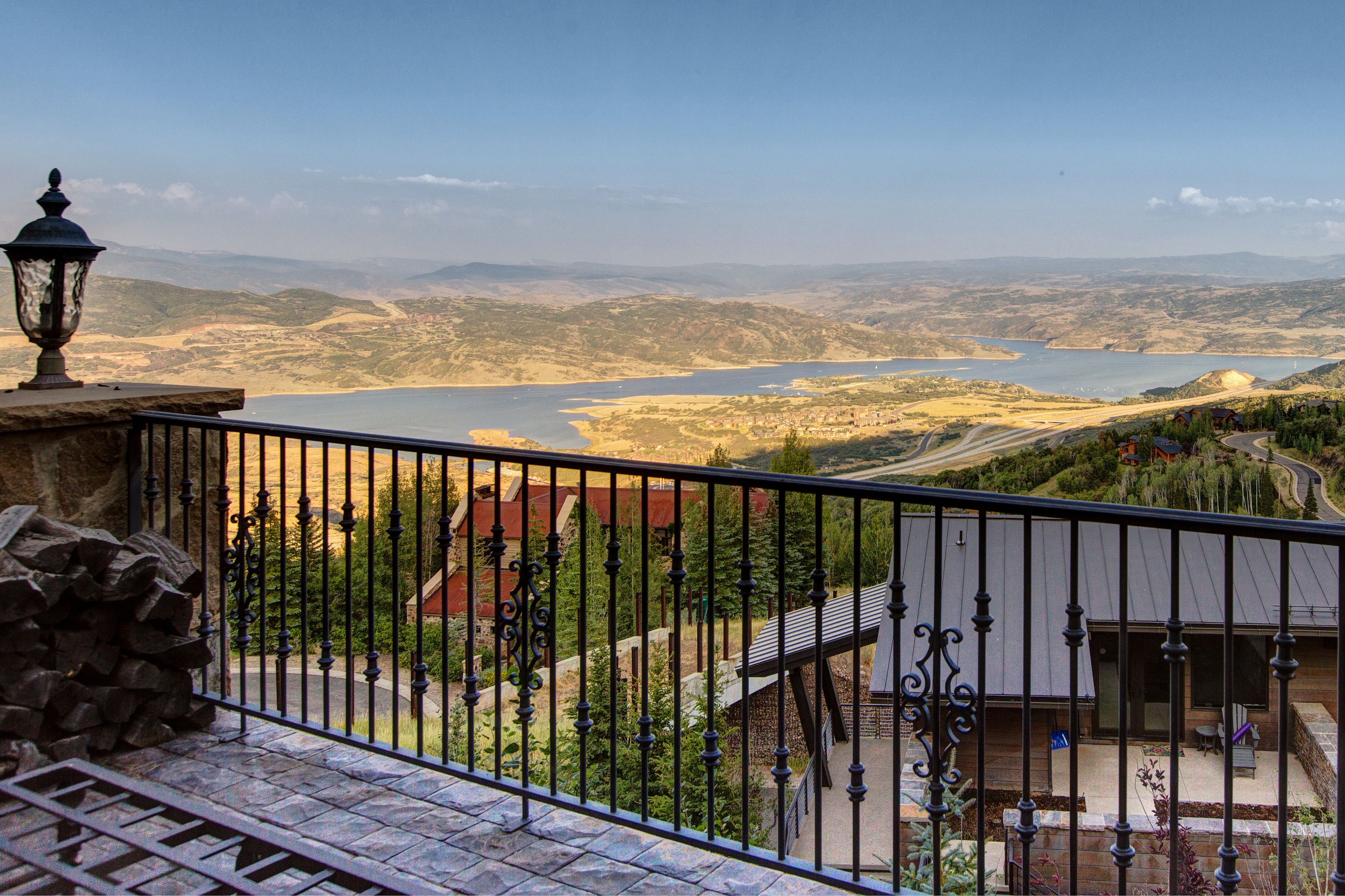 Uma varanda com vista para um lago e paisagem circundante.