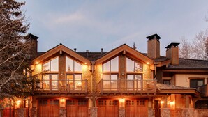 Una casa grande de varios pisos, con un balcón destacado, ventanas amplias y fachada de piedra.