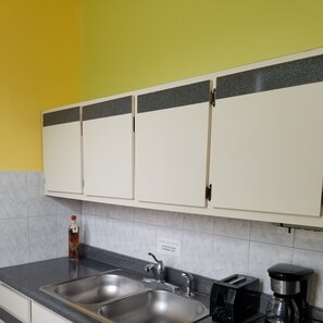 Kitchen area with double sink, toaster, and coffee maker.
