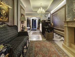 Eine prachtvolle Diele mit Teppichmuster, einer Couch, einem Chandelier und einem Empfangstresen.