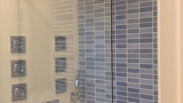 Een douche, een haardroger, handdoeken, toiletpapier