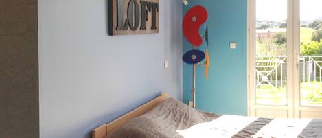 Een slaapkamer met een bed, een bord aan de muur waarop