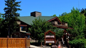 A two-story building with a stone chimney, wooden deck, and a sign for the Scandinavian Chalet.