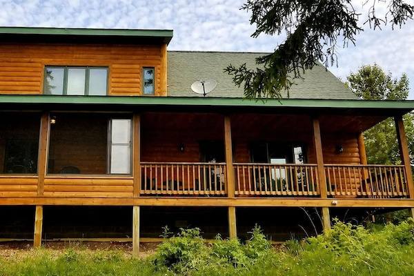 East-facing covered deck and 3-season porch offer sunrise and forest views