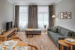 Departamento Deluxe, 1 habitación | Área de sala de estar | Televisión 