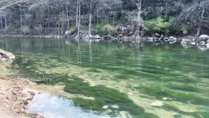 A clear lake surrounded by trees and rocks.