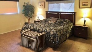 A bedroom with a bed, a nightstand, a lamp, a potted plant, and a ceiling fan. - 5 O'Clock Somewhere! WWH302 Apartment 2 New (New Braunfels)