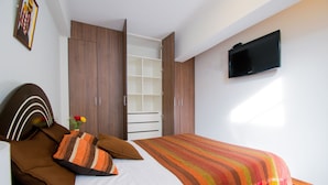 Un dormitorio con cama, televisor y armario.